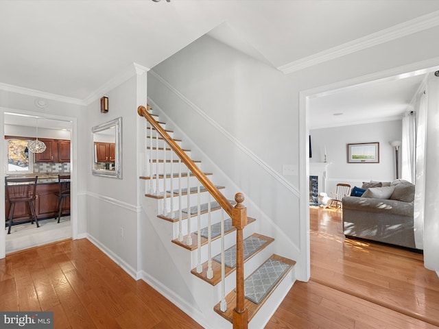 30602 Foxchase Dr, Salisbury, MD 21804 - stairway featuring crown molding, a fireplace, and hardwood / wood-style floors