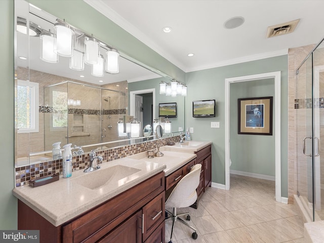 bathroom featuring backsplash, a shower with shower door, vanity, crown molding, and tile patterned flooring