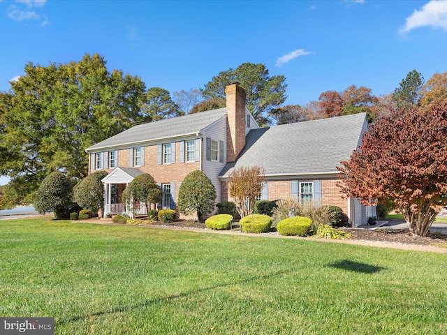 colonial inspired home featuring a front lawn