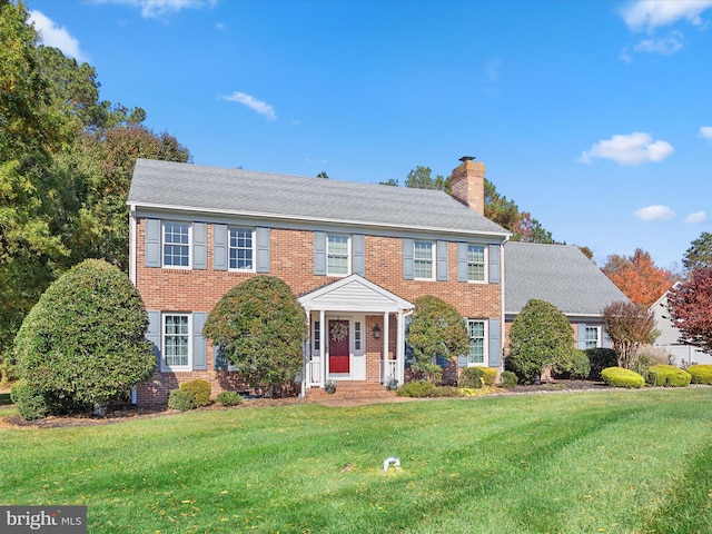 30602 Foxchase Dr, Salisbury, MD 21804 - colonial house with brick siding, a front yard, and a chimney