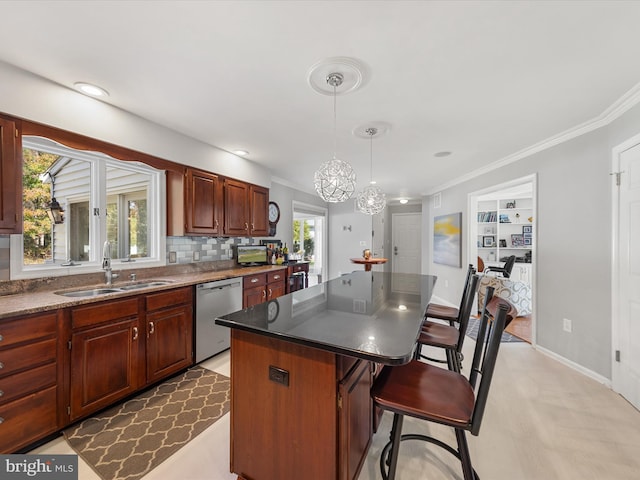 kitchen with hanging light fixtures, a healthy amount of sunlight, sink, a center island, and stainless steel dishwasher