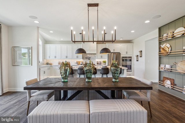 dining area with dark hardwood / wood-style floors and an inviting chandelier