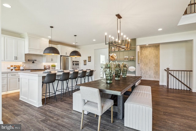 dining room with dark hardwood / wood-style floors and an inviting chandelier