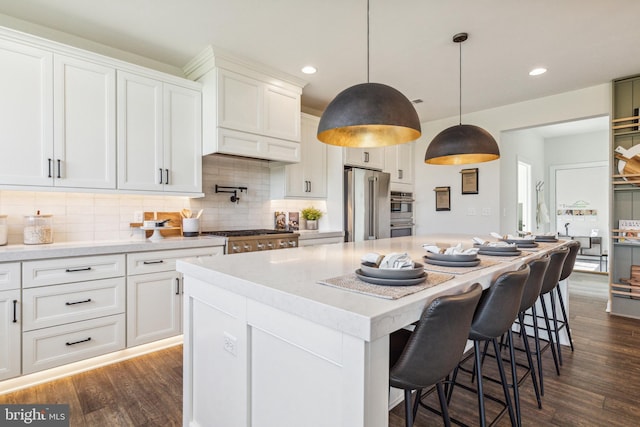 kitchen featuring white cabinetry, dark hardwood / wood-style flooring, a center island, and appliances with stainless steel finishes