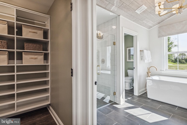 bathroom featuring separate shower and tub, an inviting chandelier, tile patterned flooring, toilet, and lofted ceiling