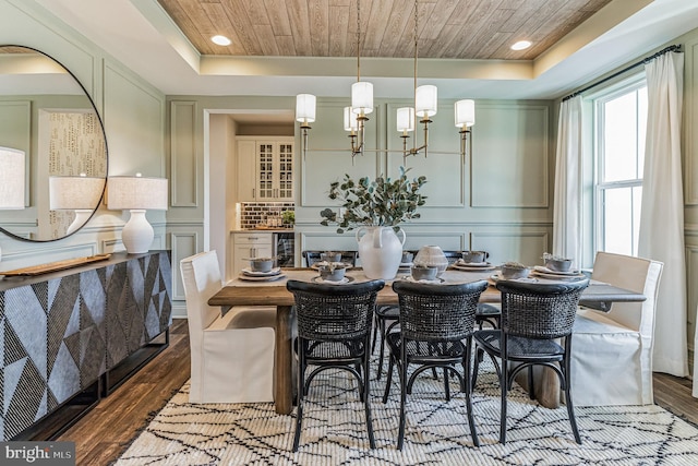 dining area featuring a tray ceiling, hardwood / wood-style floors, and beverage cooler