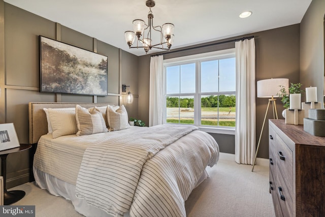 bedroom with light colored carpet and a notable chandelier