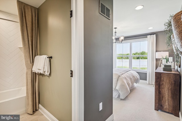 bedroom with light carpet and a chandelier