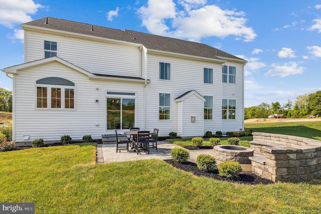 back of house with a yard, a patio, and a fire pit