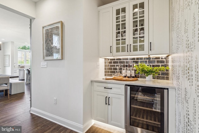 bar featuring tasteful backsplash, wine cooler, stainless steel dishwasher, dark hardwood / wood-style floors, and white cabinets