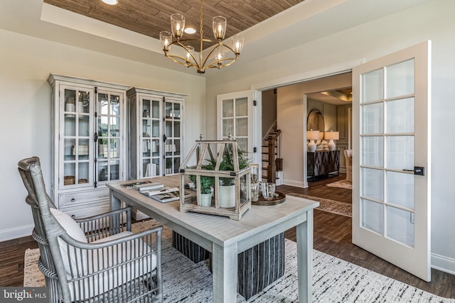 dining area with dark hardwood / wood-style floors, an inviting chandelier, wood ceiling, and french doors