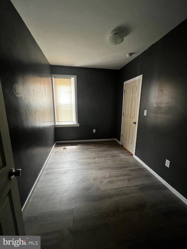 unfurnished room with wood-type flooring