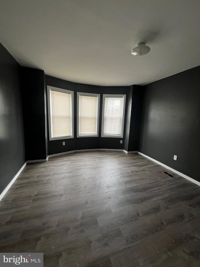 unfurnished room with dark hardwood / wood-style flooring