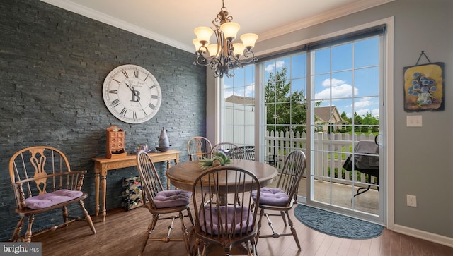 dining area with an inviting chandelier, ornamental molding, and hardwood / wood-style flooring