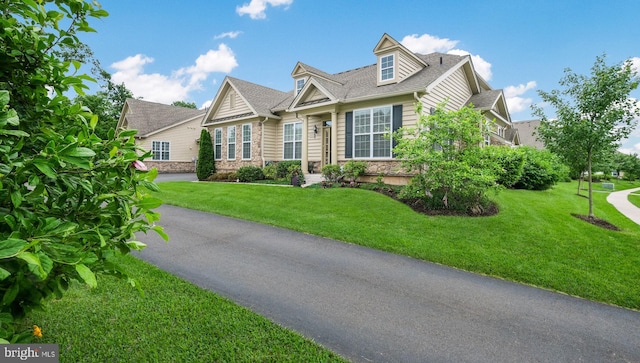 cape cod-style house featuring a front lawn