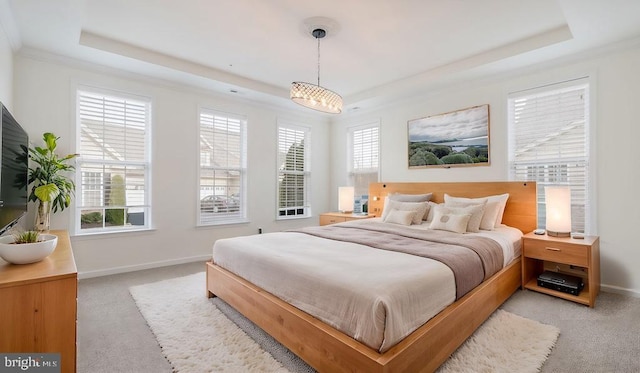 carpeted bedroom with a tray ceiling and a notable chandelier