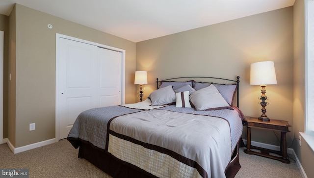 bedroom featuring light colored carpet and a closet