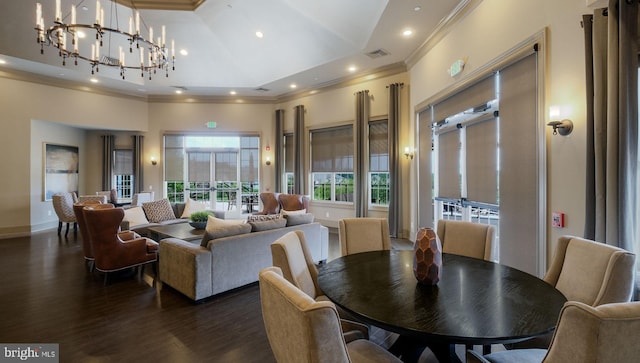 dining space with crown molding, dark hardwood / wood-style flooring, high vaulted ceiling, and an inviting chandelier