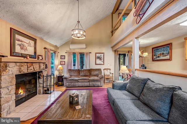 living room with a notable chandelier, an AC wall unit, a textured ceiling, vaulted ceiling, and a fireplace