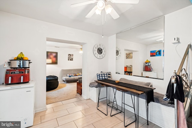 dining room featuring light carpet and a ceiling fan