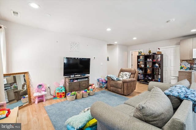 living area with baseboards, recessed lighting, visible vents, and light wood-style floors