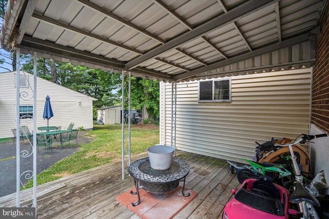 deck with a storage shed, a lawn, and an outdoor structure