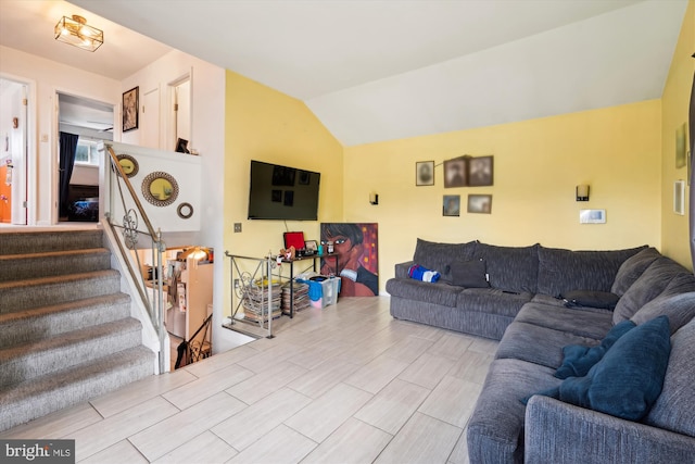 living room featuring lofted ceiling and stairs