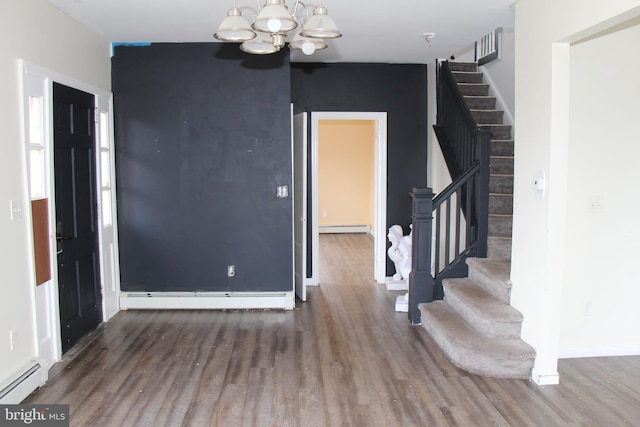 entrance foyer with dark hardwood / wood-style floors, an inviting chandelier, and a baseboard heating unit