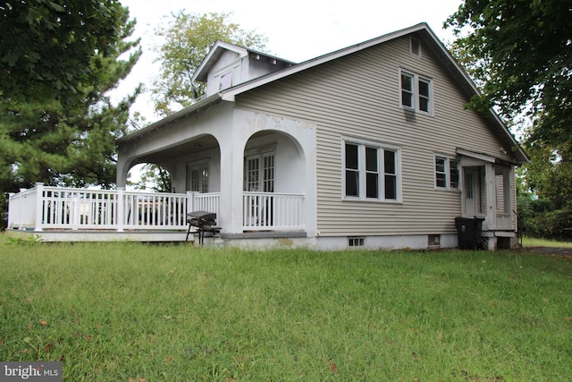 back of property featuring a porch and a yard