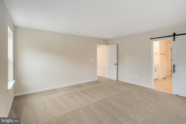 carpeted spare room with a barn door