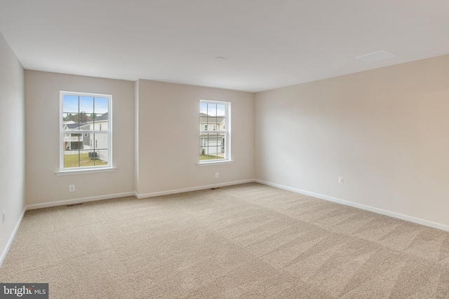 spare room featuring light carpet