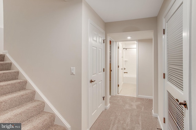 hall featuring light colored carpet