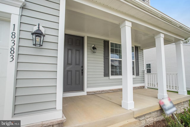 view of exterior entry featuring covered porch