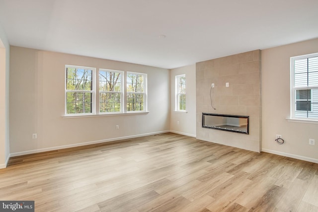 unfurnished living room with light wood-type flooring and a wealth of natural light