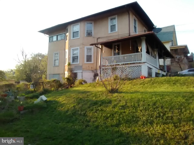 back of house featuring a lawn and a porch