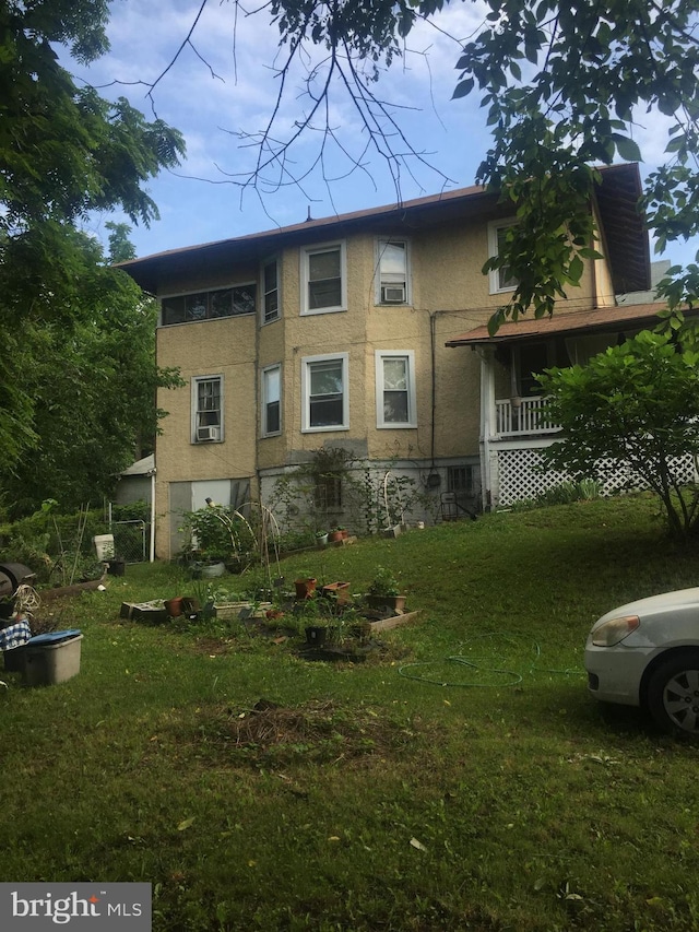 view of side of home featuring a lawn and covered porch