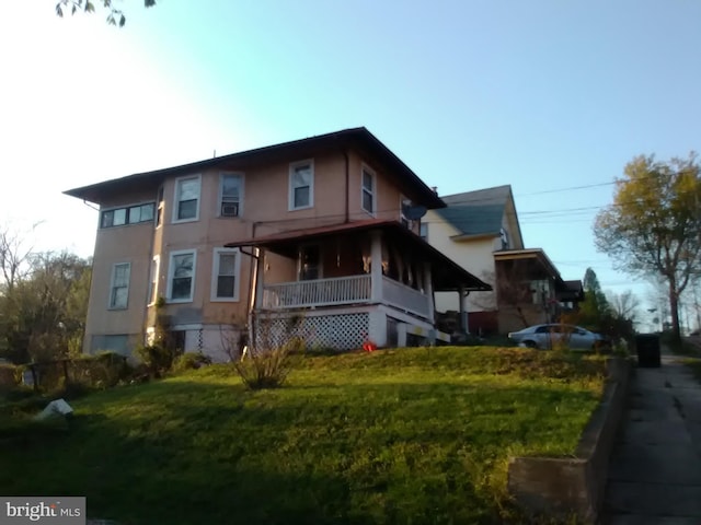 exterior space with covered porch and a yard