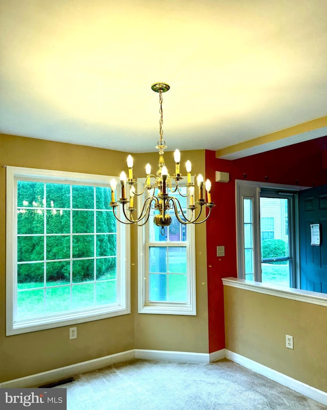 unfurnished dining area featuring carpet flooring and a notable chandelier