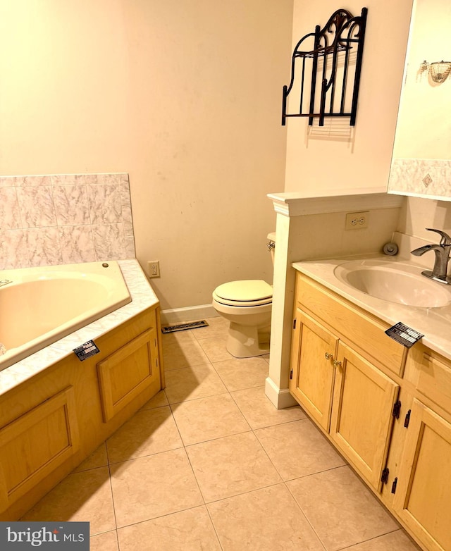 bathroom featuring tile patterned floors, a bathing tub, vanity, and toilet