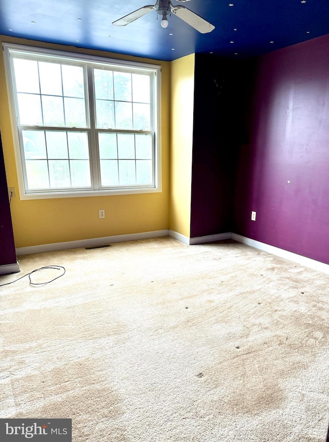 carpeted spare room featuring ceiling fan