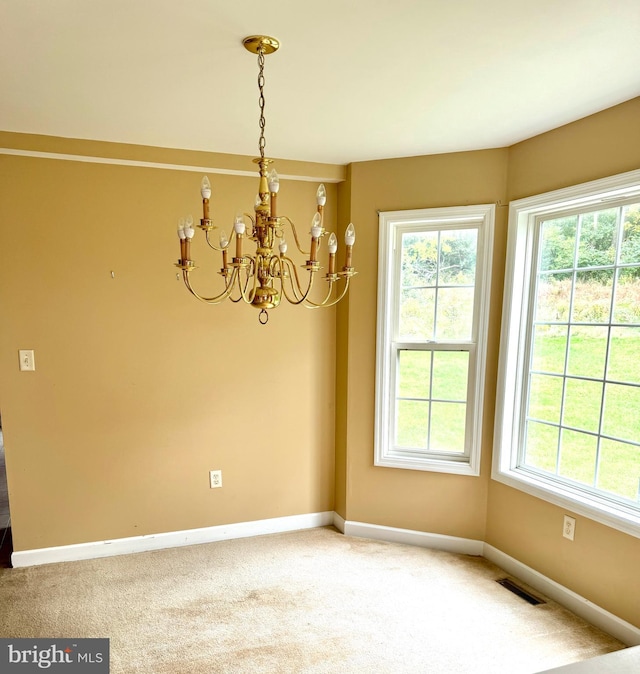 unfurnished dining area with carpet flooring and an inviting chandelier