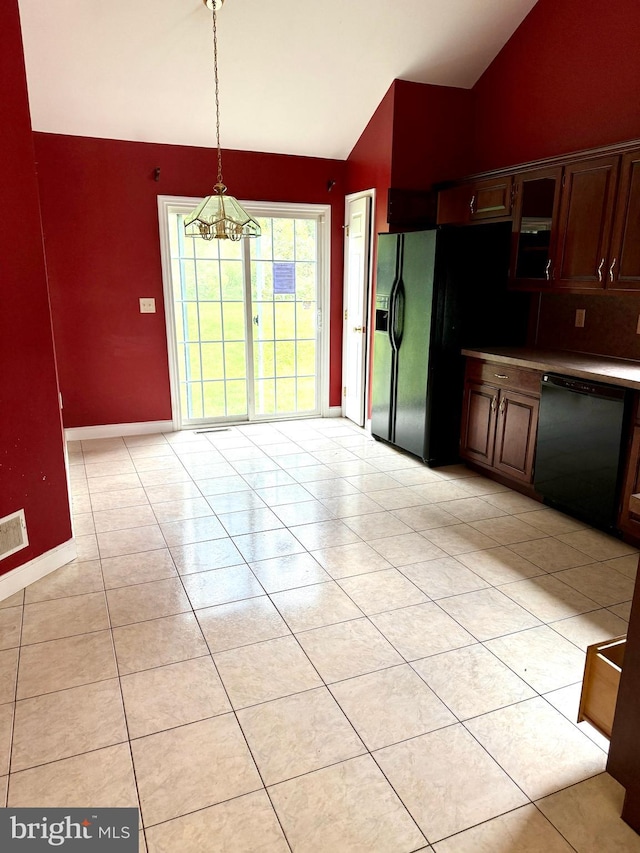 kitchen with an inviting chandelier, black appliances, hanging light fixtures, vaulted ceiling, and light tile patterned flooring