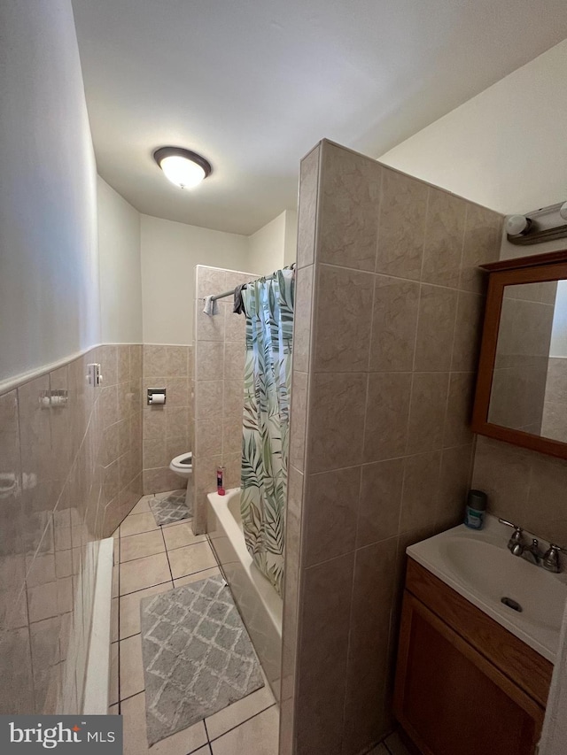 full bathroom with shower / bath combo, tile patterned floors, vanity, tile walls, and toilet