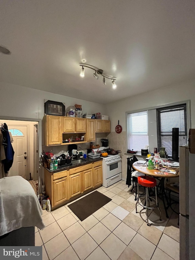 kitchen with white gas range and light tile patterned flooring