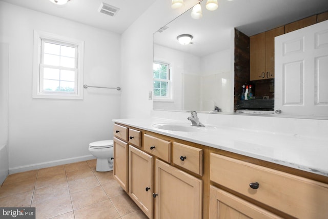 bathroom with toilet, vanity, and tile patterned floors