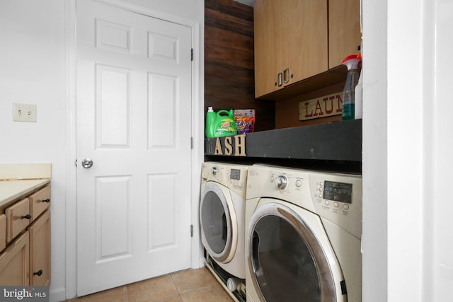 washroom featuring cabinets, separate washer and dryer, and light tile patterned floors