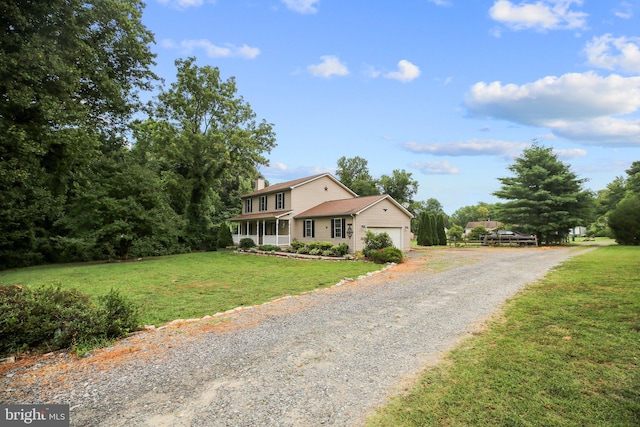 view of front of property featuring a garage, a front lawn, and a porch