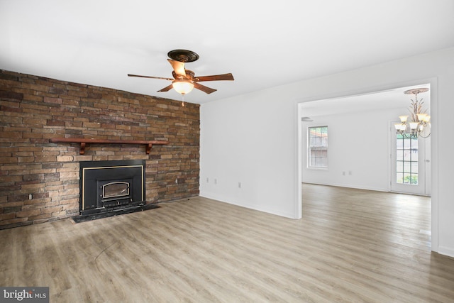 unfurnished living room featuring light hardwood / wood-style floors, a chandelier, and a fireplace