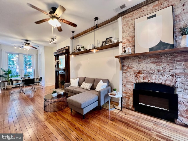 living room with light hardwood / wood-style floors and ceiling fan