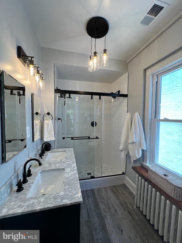 bathroom with radiator, plenty of natural light, and an enclosed shower